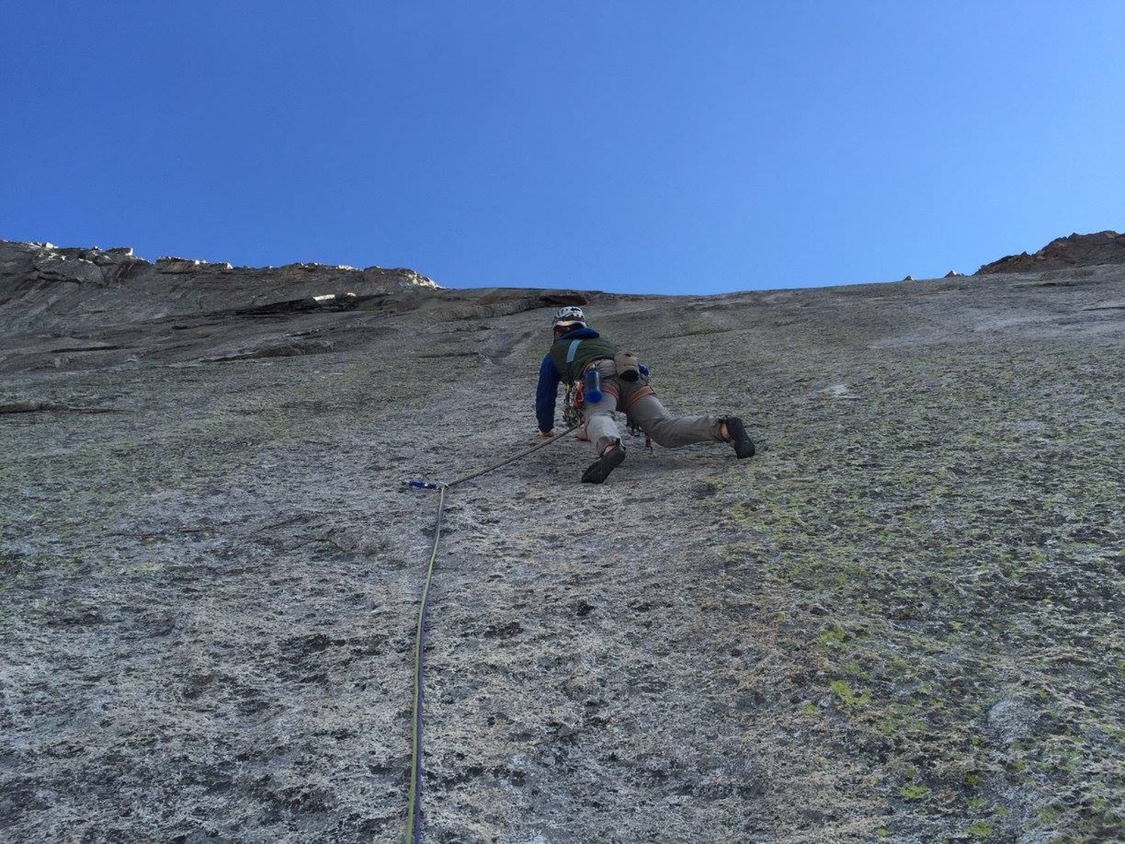 Climber ascending a steep granite route