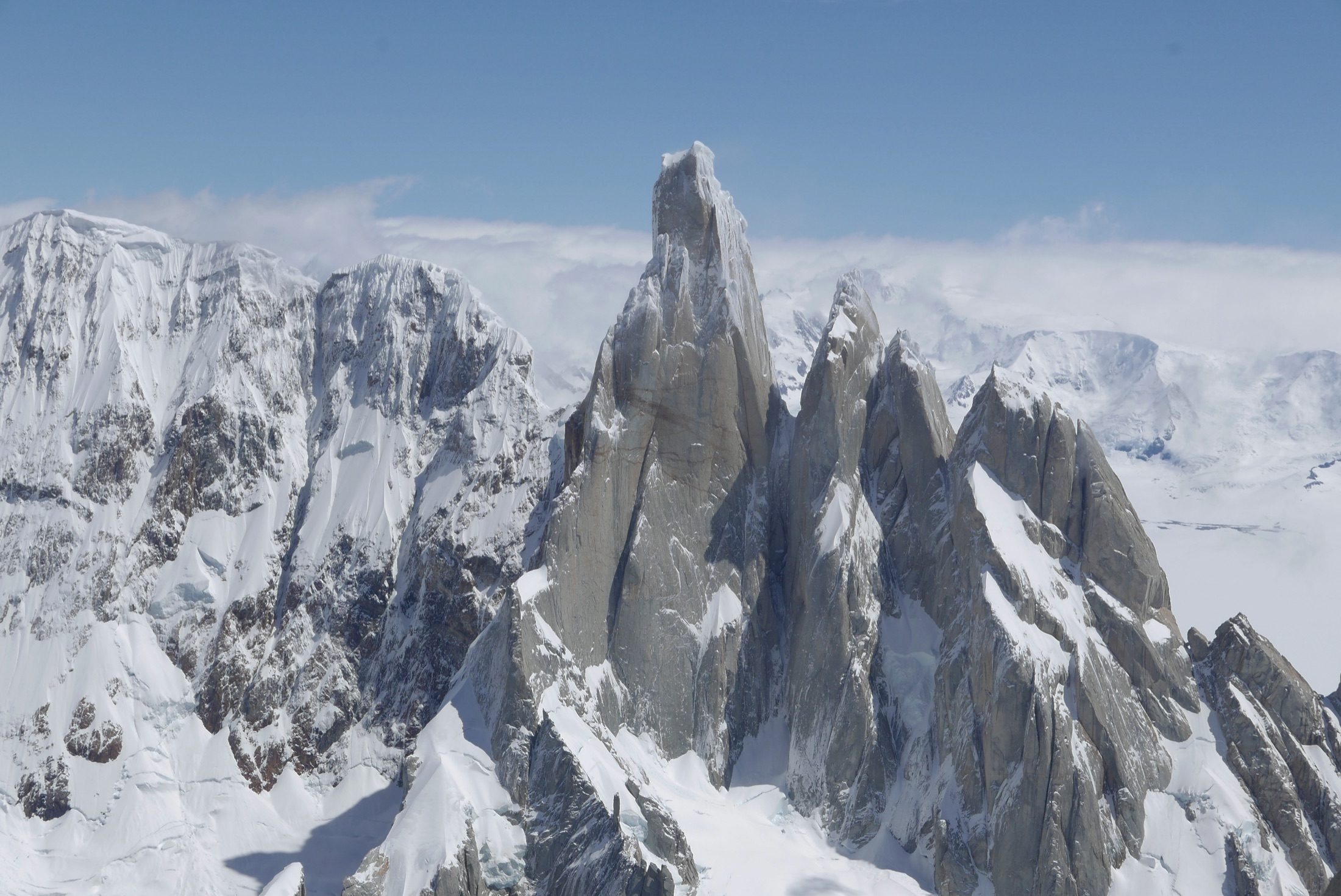 Cerro Torre and surrounding peaks under a blue sky
