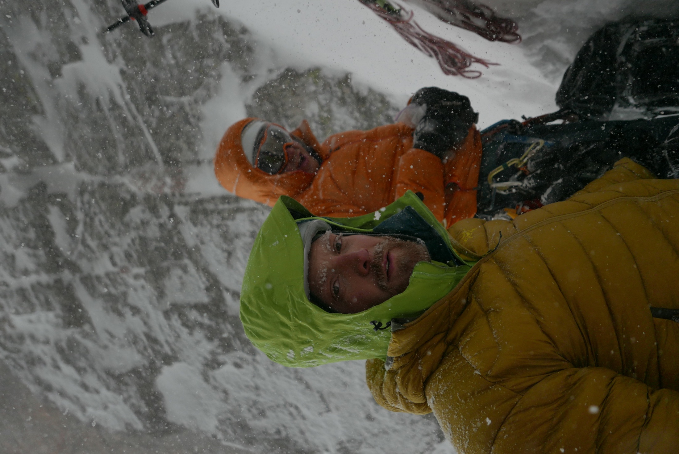 A weathered climbing team smiling in the mountains