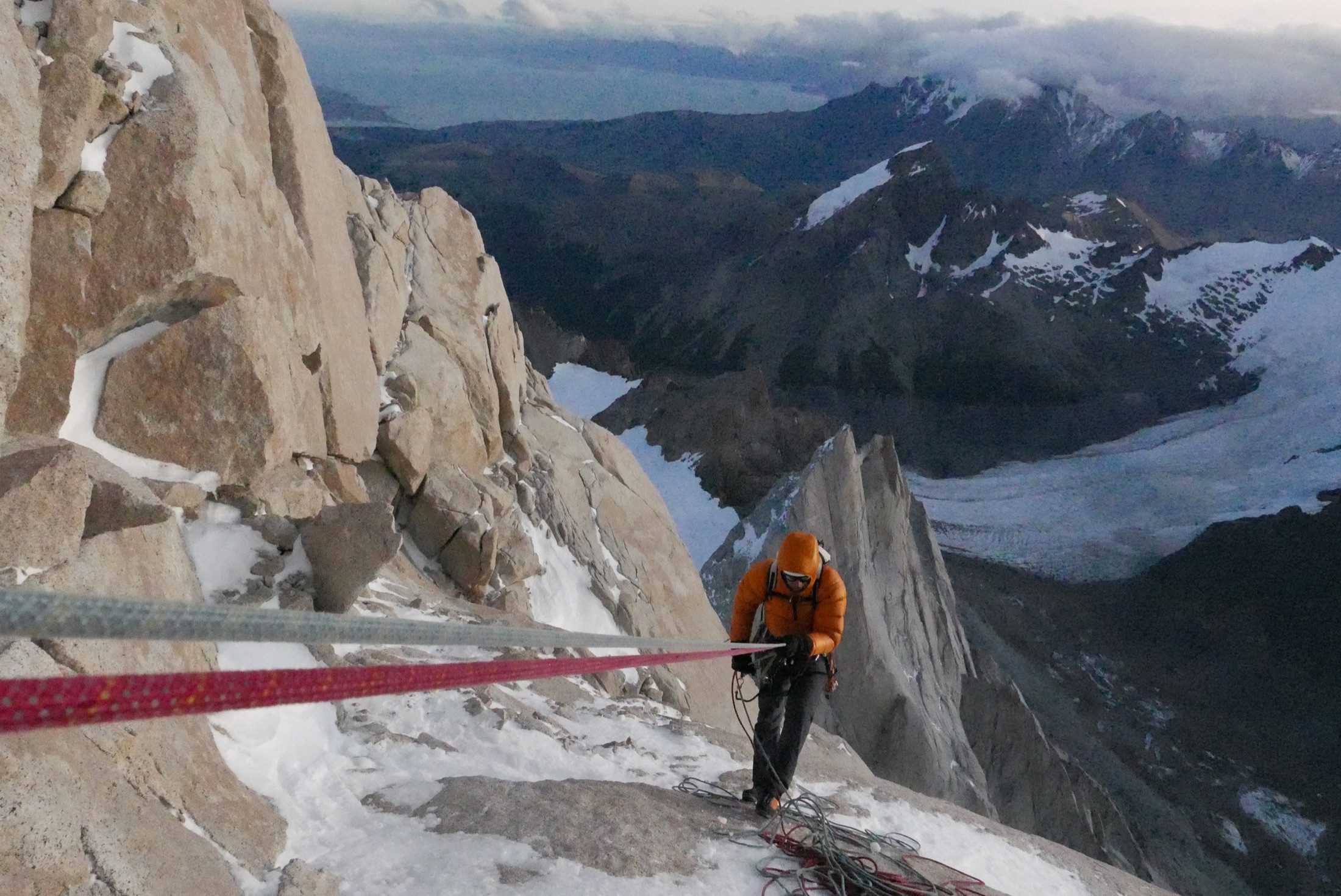 Climber rappelling down an icy mountain face